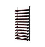Full black wine bottle display rack with rows of bottles and red bottle tops