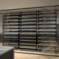Tall wine bottle display wall with multiple tiers of assorted wine bottles