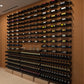 Large label-out bottle display wall with black racks holding bottles on open shelves