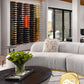 Aluminum wine bottle display wall with multi-colored bottles behind a modern sofa