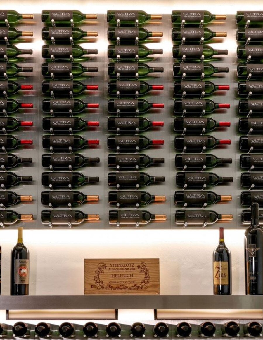 Aluminum wine bottle display wall with tightly arranged bottles in a wall grid
