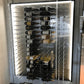 Aluminum wine bottle display panel with rows of bottles and metal holding pegs