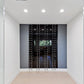 Black wine bottle wall rack with peg rails holding bottles in a built-in panel