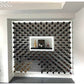 Installed wine bottle wall display with many cork-out bottles on dark peg grid