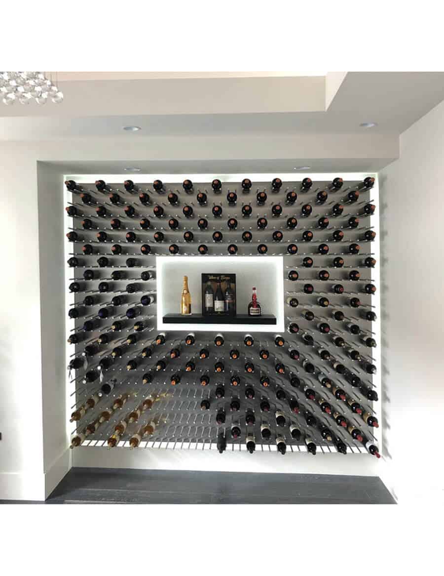 Installed wine bottle wall display with many cork-out bottles on dark peg grid