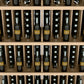 Close-up of light wood wine bottle display with rows of bottles behind dividers