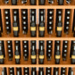 Wall wine bottle display rack with five shelves, bottles in individual slots