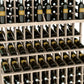 Triple-tier wine bottle display rack with double-deep base; light wood frame holding wine bottles