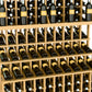Triple-tier wine bottle display rack with front bottle slots and light wood frame