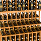 Light wood triple-tier wine bottle display rack with double-deep base, holding dark bottles