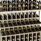Close-up of wine bottles arranged in three tiers on a light wood rack frame