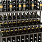 Close-up of triple-tier wine bottle display with dark gray slatted shelves and bottles