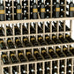 Close-up view of stacked wine bottles in triple-tier wooden grid rack