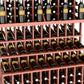 Close-up view of wine bottle display rack with three wooden shelves holding bottles