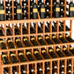 Triple-tier wine bottle display rack with natural wood lattice and bottle neck holders