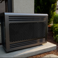Outdoor cooling condenser with front grille on a concrete base