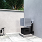 Wall-mounted cooling condenser with vented grille and connected drain line on pad